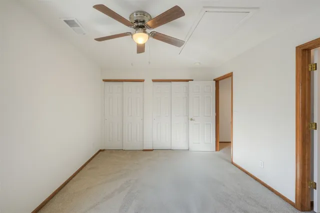 an empty room with a ceiling fan and a window