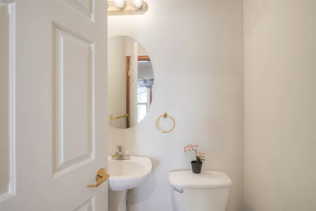 a bathroom with a sink a toilet and mirror