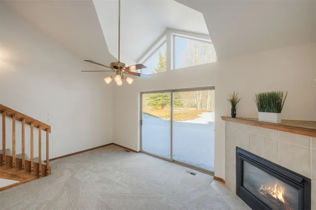 a view of an empty room with a fireplace and a window