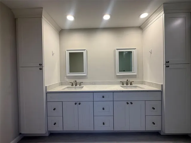 a bathroom with double vanity sinks and a mirror