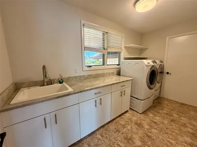 a utility room with sink dryer and washer