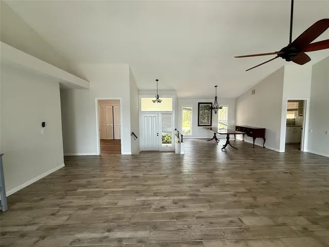 a view of empty room with kitchen and window