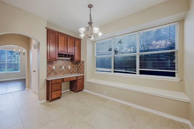 a view of spacious kitchen with granite countertop cabinets and refrigerator