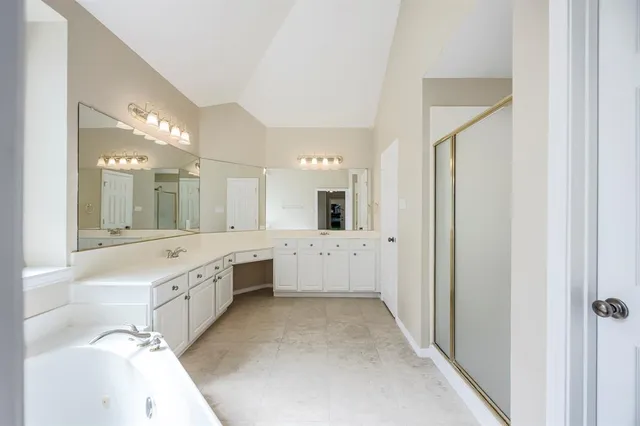 a large bathroom with a large mirror vanity and shower