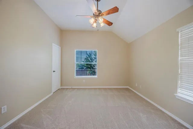 an empty room with a window and a fan