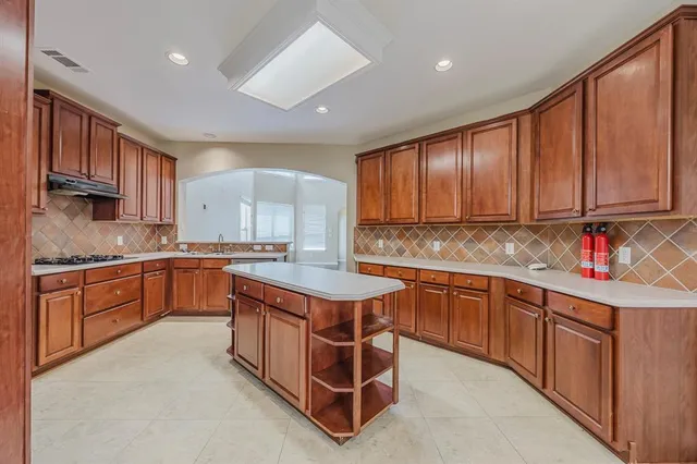 a kitchen with stainless steel appliances granite countertop wooden cabinets a sink and dishwasher a refrigerator with wooden cabinets