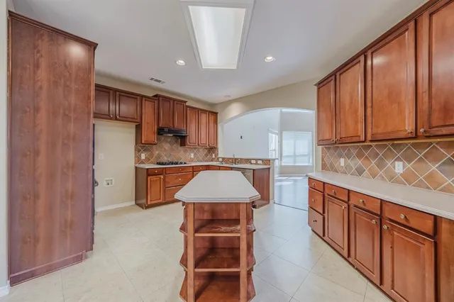 a kitchen with stainless steel appliances granite countertop wooden cabinets a stove top oven a sink and dishwasher