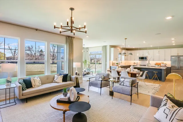 a living room with furniture kitchen view and a large window