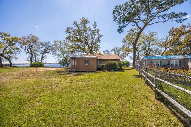 a view of a house with a yard and large tree