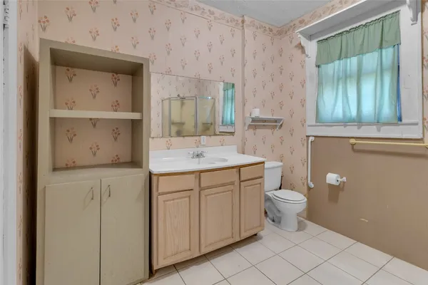 a bathroom with a granite countertop sink mirror vanity and toilet