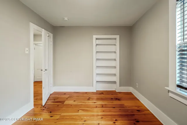 a view of a room with a window and wooden floor