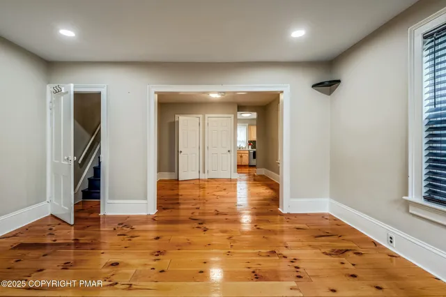 an empty room with wooden floor and a window