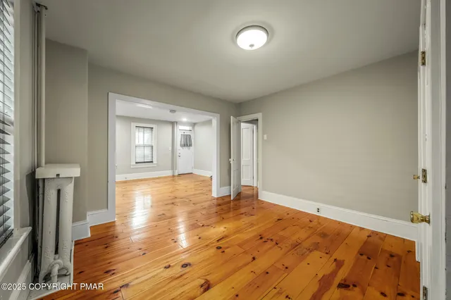 a view of empty room with wooden floor and front door