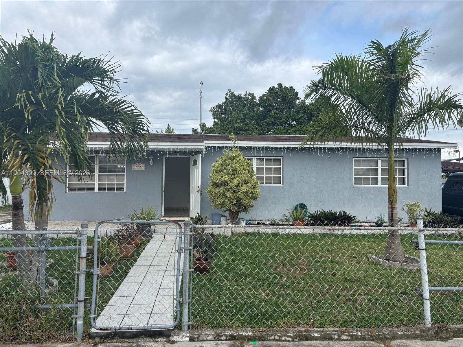 front view of house with a yard and potted plants