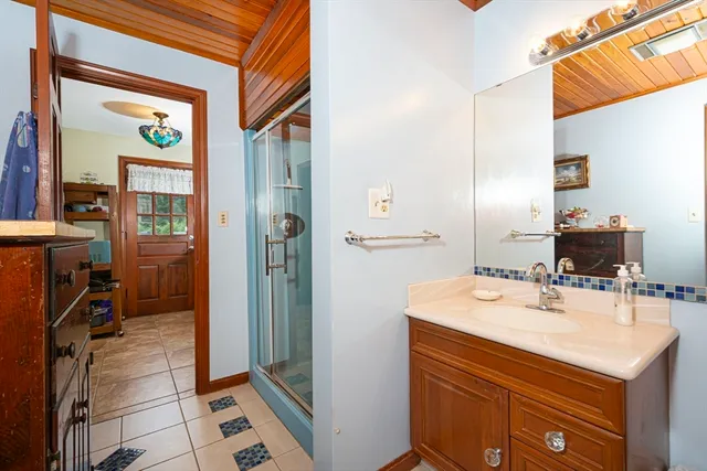 a bathroom with a sink mirror and shower