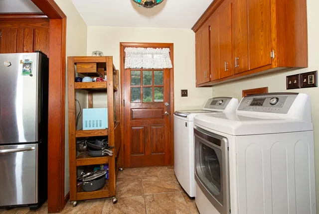 a utility room with dryer washer and a fridge