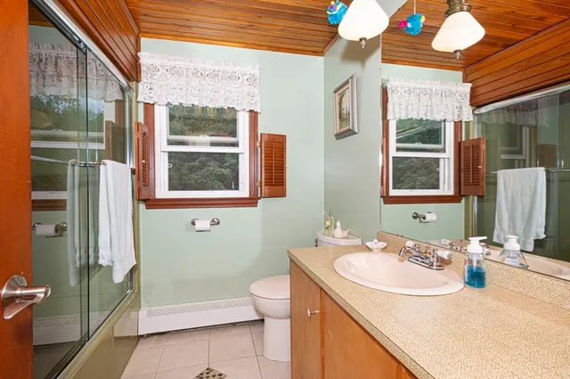 a bathroom with a sink a toilet and shower