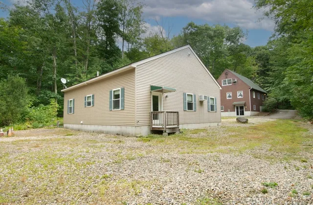 a view of a house with a yard and sitting area