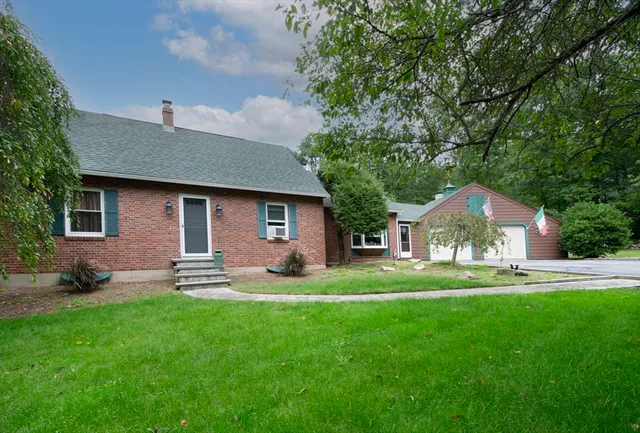 a front view of a house with a garden and trees
