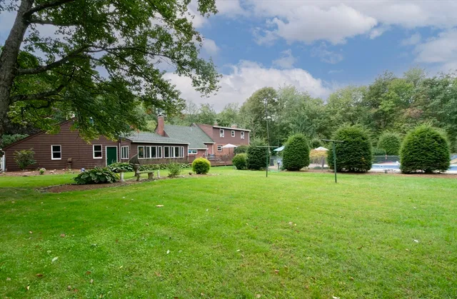 a front view of a house with a yard and trees