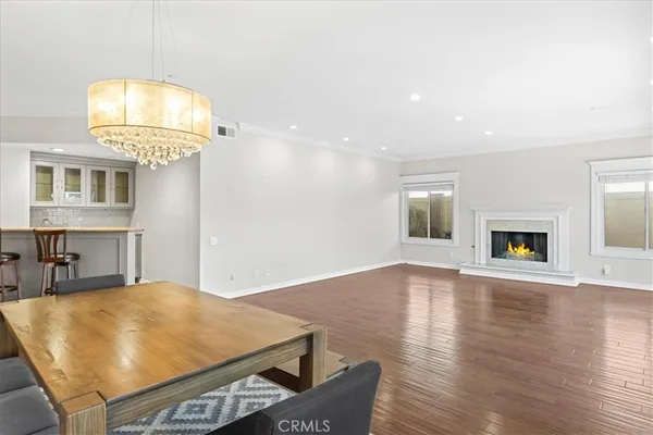 a dining room with wooden floor a glass table and chairs