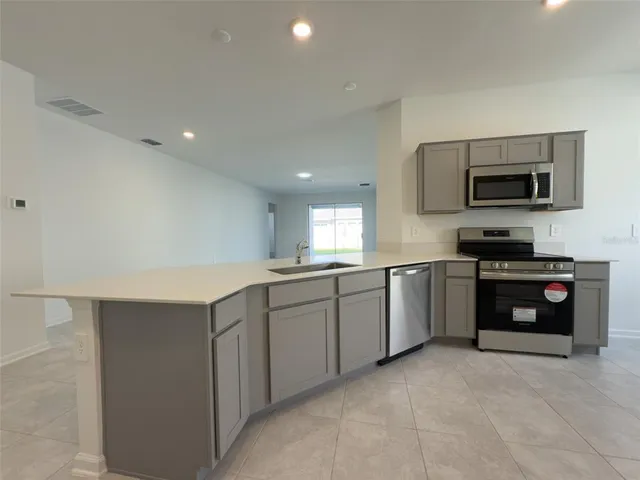 a kitchen with stainless steel appliances a stove sink microwave and cabinets