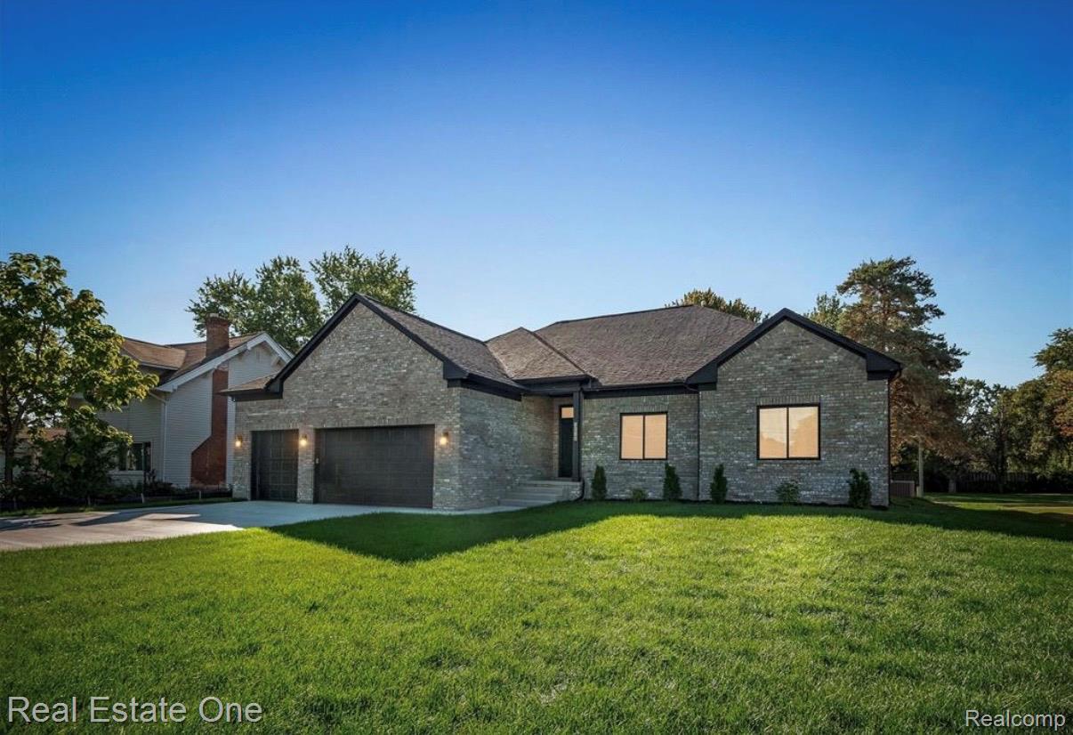 5636 Paris Street Sterling Heights, MI 48310 - Photo 1 of 37 View of front of property with a front yard, an attached garage, concrete driveway, and brick siding