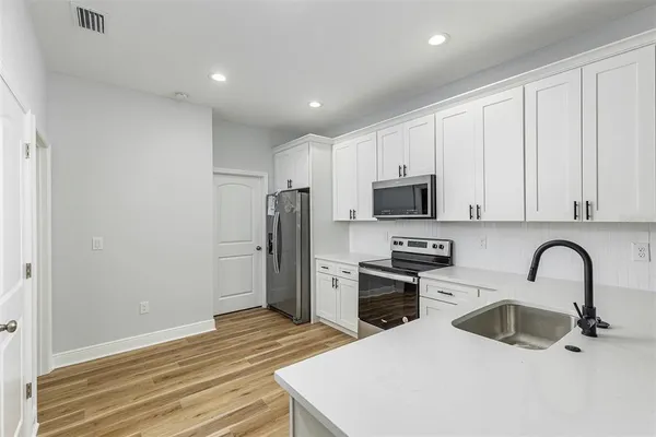 a kitchen with granite countertop a refrigerator and a sink