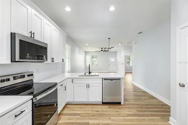 a kitchen with stainless steel appliances a stove sink microwave and cabinets