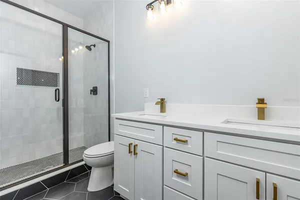 a bathroom with a sink a toilet and shower