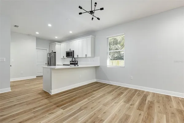 a view of kitchen with wooden floor electronic appliances and window