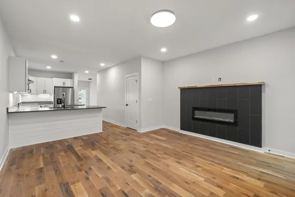 a view of empty room with wooden floor