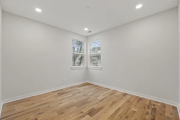 a view of empty room with wooden floor