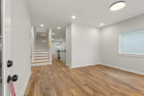 a view of empty room with wooden floor and window