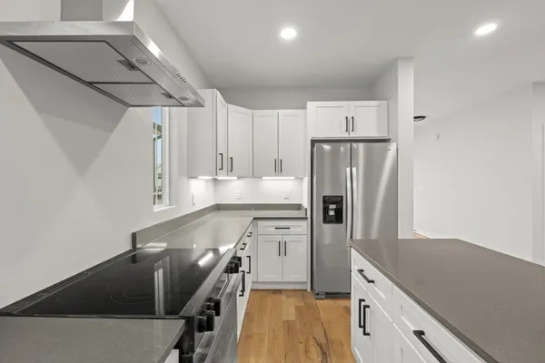 a large kitchen with stainless steel appliances lots of counter space and wooden floor