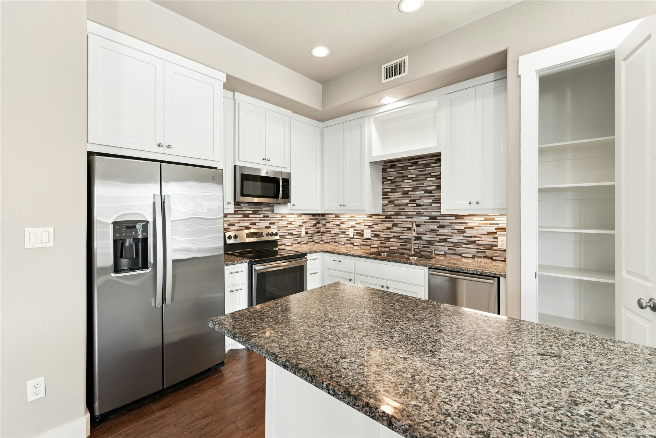 4301 Mansfield Dam Road, Unit 2101 Austin, TX 78734 - Photo 9 of 17 Kitchen with stainless steel appliances, dark stone counters, white cabinetry, decorative backsplash, and dark wood-type flooring