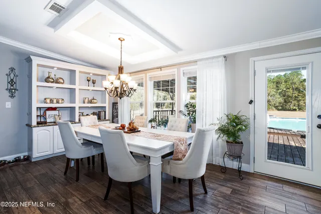 a kitchen with kitchen island granite countertop a dining table chairs and a refrigerator