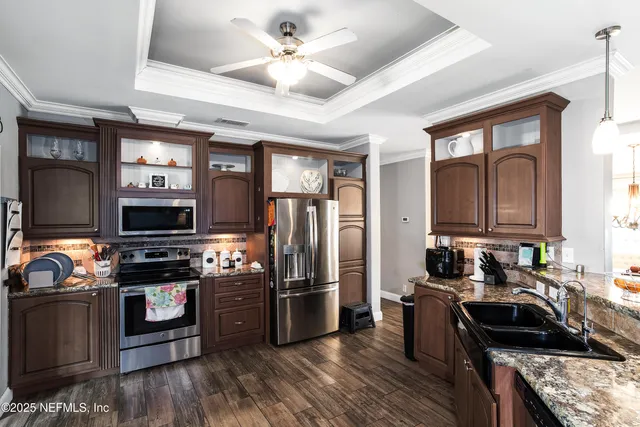 a kitchen with kitchen island granite countertop a sink a stove and cabinets