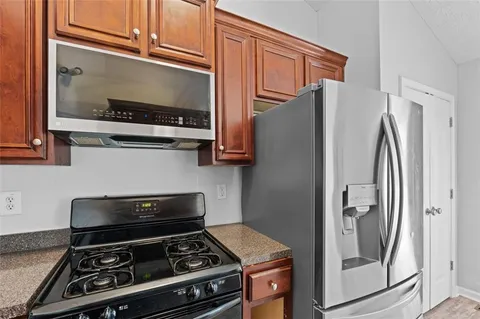 a kitchen with stainless steel appliances granite countertop a refrigerator and a stove top oven