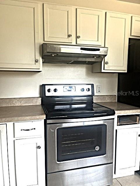 12 Pine Course Way Ocala, FL 34472 - Photo 13 of 29 a stove top oven sitting inside of a kitchen with stainless steel appliances wooden floor