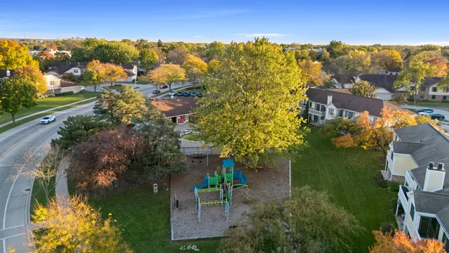 an aerial view of residential houses with outdoor space and trees