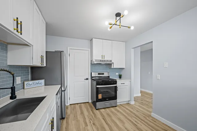 a kitchen with stainless steel appliances granite countertop a sink stove and refrigerator