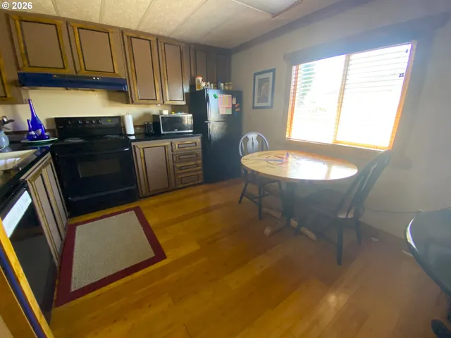 a kitchen with stainless steel appliances a stove a sink a microwave a refrigerator and cabinets