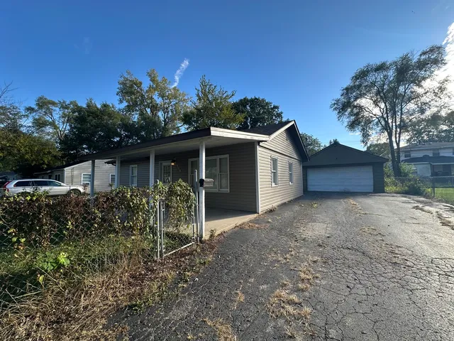 a front view of house with yard and trees in the background