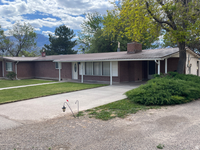 438 East Main Street Elsinore, UT 84724 - Photo 1 of 43 Brick facade residence with a covered entryway, attached carport, white siding accents, and a metal roof