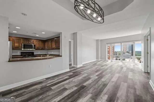 a view of a livingroom with wooden floor and staircase