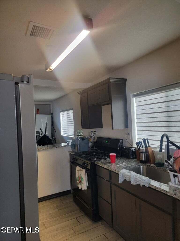 11531 Ernest Road Socorro, TX 79927 - Photo 18 of 36 a kitchen with granite countertop a sink cabinets and stainless steel appliances