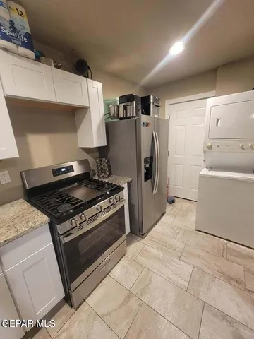 a kitchen with stainless steel appliances a dining table chairs microwave and sink