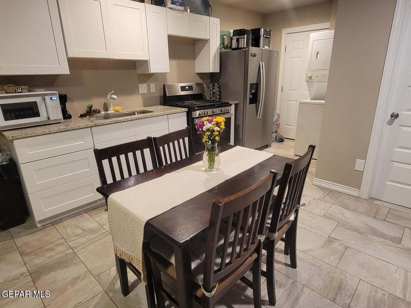 11531 Ernest Road Socorro, TX 79927 - Photo 28 of 36 a kitchen with stainless steel appliances a dining table chairs microwave and sink