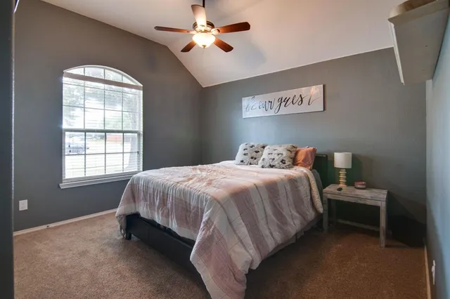 a spacious bedroom with a bed and a window